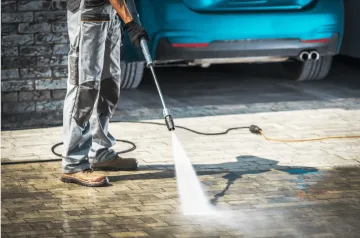 image of man cleaning driveway with pressure washer