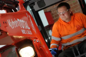 Close up image of Total Hire Sales employee using hire equipment
